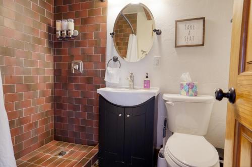 a bathroom with a toilet and a sink and a mirror at Ponderosa Cabin at Highland Meadows in Hot Springs