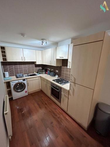 a kitchen with white cabinets and a refrigerator at Thornaby Lodge in Thornaby on Tees
