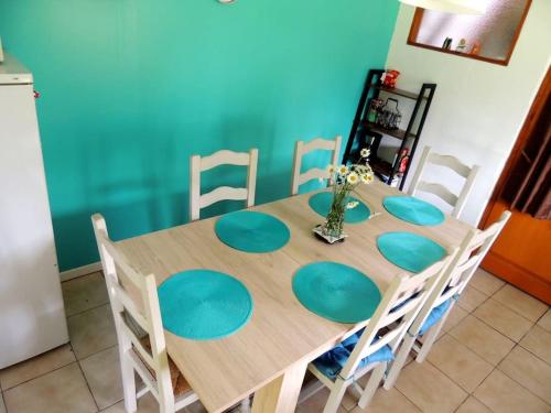 a dining room table with chairs and a blue wall at La Séliniére ! in Champ-du-Boult