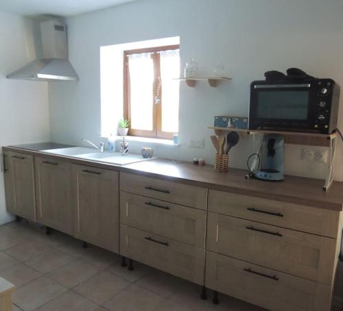 a kitchen with a sink and a tv on a counter at La Séliniére ! in Champ-du-Boult