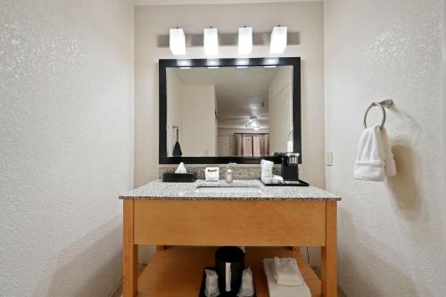 a bathroom with a sink in front of a mirror at Best Western Plus Executive Inn & Suites in Manteca