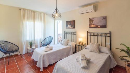 pokój z 2 łóżkami i 2 krzesłami w obiekcie Villa Gran Solano Colmenar by Ruralidays w mieście Colmenar