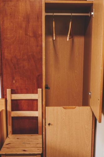 a closet with a wooden door and a wooden chair at Crianlarich Youth Hostel in Crianlarich