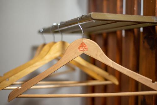 a bunch of wooden utensils hanging from a rack at Crianlarich Youth Hostel in Crianlarich