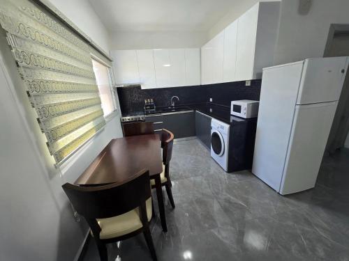 a small kitchen with a table and a refrigerator at Chouf View Residence in Baddah
