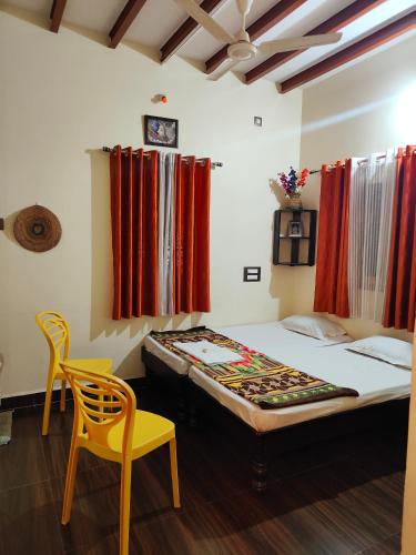 Un dormitorio con una cama y una silla amarilla. en Sri Sai homestay, en Hampi