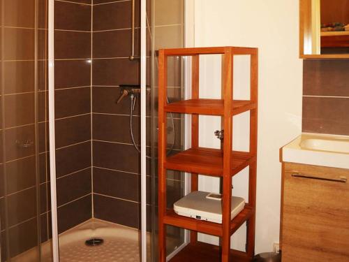 La salle de bains est pourvue d'une douche et d'une étagère en bois. dans l'établissement Studio familial 4 pers, skis aux pieds, proche centre - FR-1-322-229, aux Orres