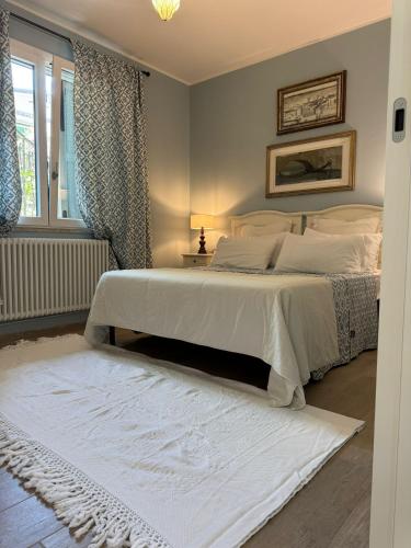 a bedroom with a white bed with a white rug at Pesciolino Rosso in Cesenatico
