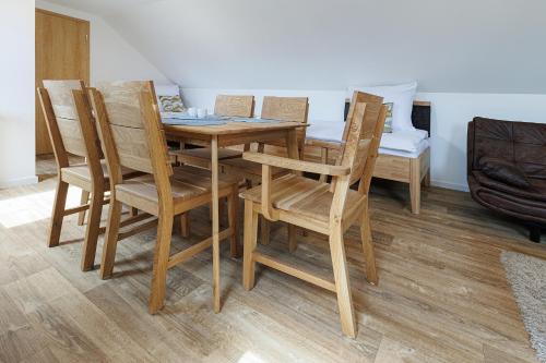 a wooden dining room table with chairs and a table and a couch at APARTMÁNY Sninský dvor in Snina