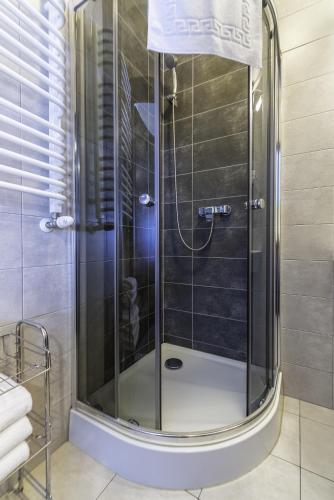 a shower with a glass door in a bathroom at FRAJDA Dom Wypoczynkowy in Rewal