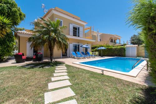 a villa with a swimming pool in front of a house at Altura Villa in Altura