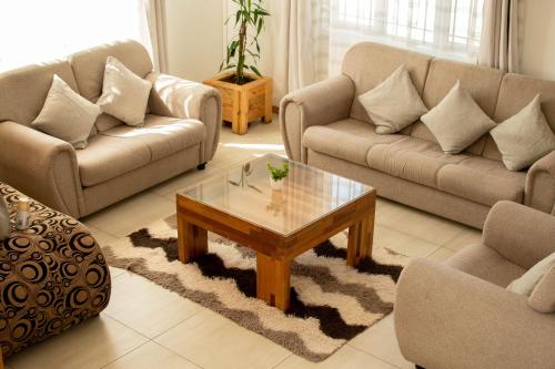 a living room with two couches and a coffee table at Red Fody Villa in Triolet