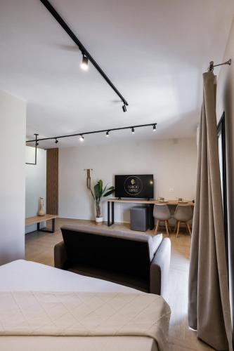 a bedroom with a bed and a living room at Baron Suites in Vasiliki