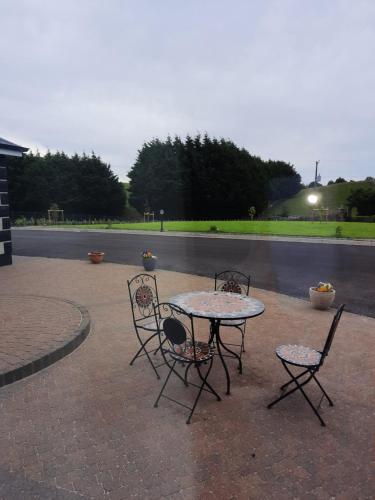 a table and four chairs sitting on a patio at Ballnamona house in Cong