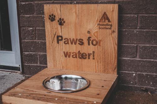 a sign that says paws for water in a wooden box at Crianlarich Youth Hostel in Crianlarich