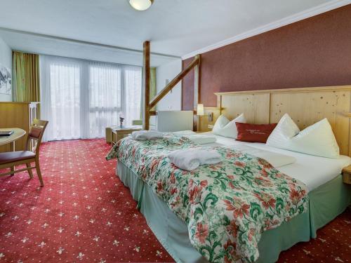 a hotel room with two beds and a desk at VÖTTER'S HOTEL in Kaprun - summer card included in Kaprun