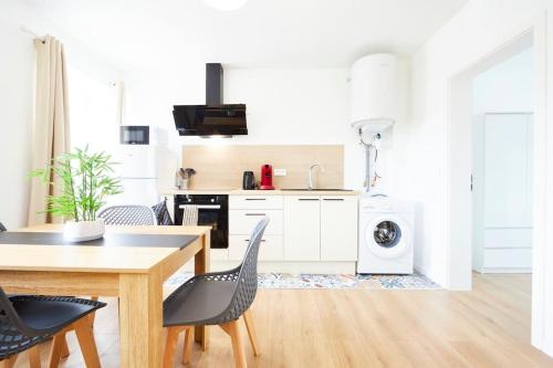une cuisine avec une table et des chaises dans une pièce dans l'établissement RB-2D - Appartement F2 au 2ème étage à Mulhouse de 1 à 3 pers, à Mulhouse