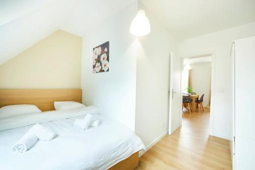 - une chambre blanche avec 2 lits et une table dans l'établissement RB-2D - Appartement F2 au 2ème étage à Mulhouse de 1 à 3 pers, à Mulhouse