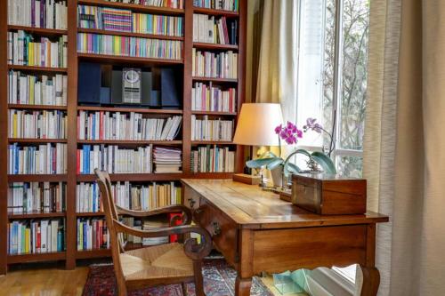 une bibliothèque avec un bureau devant une fenêtre dans l'établissement GuestReady - Séjour raffiné près de la Tour Eiffel, à Paris