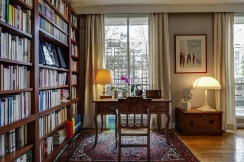 une bibliothèque avec un bureau et une chaise dans une pièce dans l'établissement GuestReady - Séjour raffiné près de la Tour Eiffel, à Paris