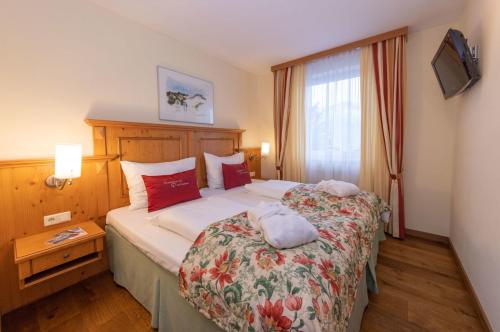 a hotel room with a large bed and a window at VÖTTER'S HOTEL in Kaprun - summer card included in Kaprun