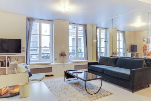 un salon avec un canapé et une table dans l'établissement GuestReady - Appt d'architecte dans le Marais, à Paris
