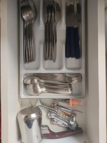 a drawer filled with utensils and a sink at Astros Family Apartment in Paralion astros