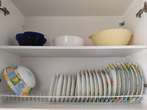 a shelf with bowls and other dishes in a refrigerator at Astros Family Apartment in Paralion astros
