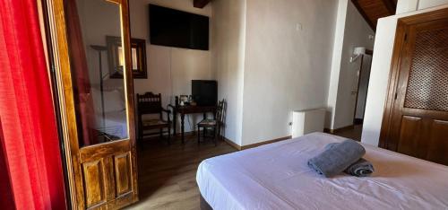 a bedroom with a bed and a mirror and a table at Hospedium Hotel Rural Abadía de Yuste in Cuacos de Yuste