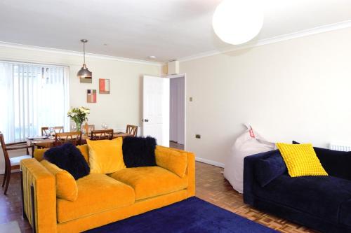 a living room with an orange couch and a table at Family Seaside Bungalow - Max 6 Adults Only in Margate