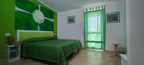 a green bedroom with a bed and a window at Gullo Capo Vaticano in Ricadi