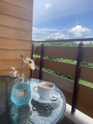 a table with a cup of coffee and a vase with a flower at Villa Pino in Velingrad