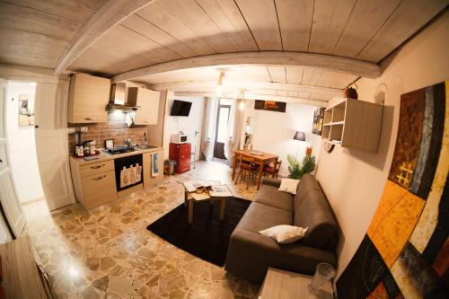 a living room with a couch and a kitchen at L'ombelico del Monte - appartamenti in centro storico in Piazza Armerina