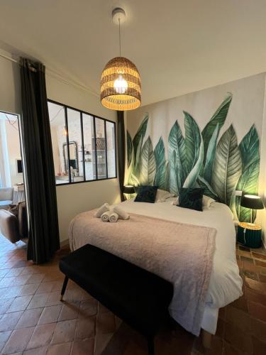 - une chambre avec un lit orné d'une grande fresque murale de feuilles dans l'établissement Côté Escaliers - Cosy appartement au cœur de Blois, à Blois