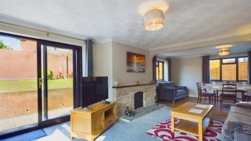 a living room with a fireplace and a tv at Dartmouth House in Totland
