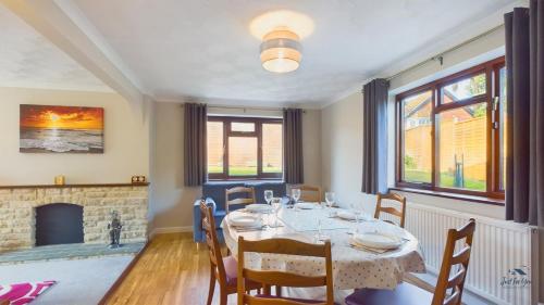 a dining room with a table and a fireplace at Dartmouth House in Totland