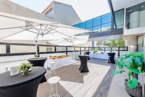 a rooftop patio with tables and chairs on a building at Eurostars Málaga in Málaga
