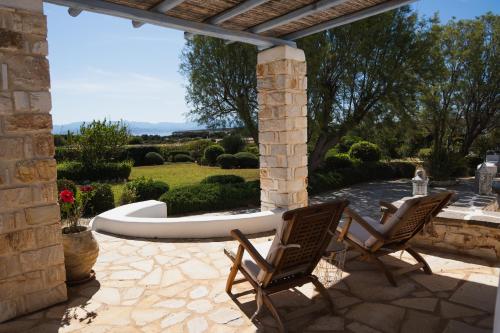 two chairs sitting on a patio with a fountain at Kalma villa in Santa Maria