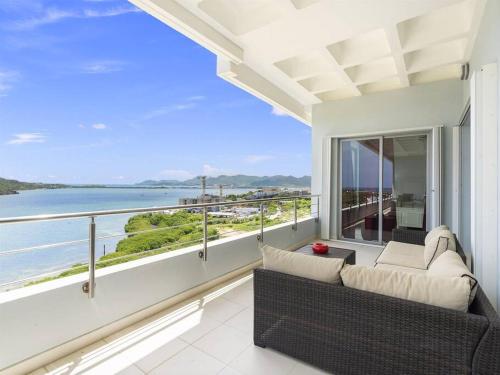 a balcony with a couch and a view of the ocean at Breathtaking Lagoon Views At Blue Residence in Cupecoy
