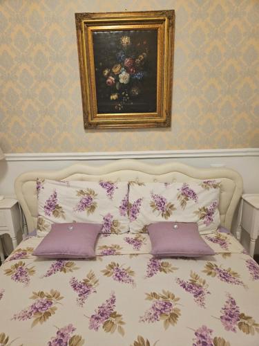 a bed with purple pillows and a painting on the wall at Heart of Verona in Verona