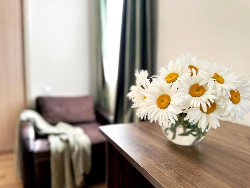 a vase filled with white flowers sitting on a table at Betlemi Old Town Hotel in Tbilisi City