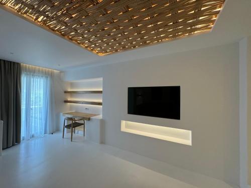 a living room with a television on a wall at Yialos Ios Hotel in Ios Chora