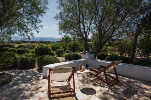 a patio with two chairs and a table at Kalma villa in Santa Maria
