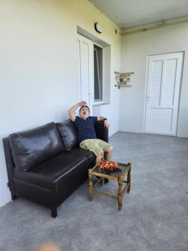 a man sitting on a leather couch with his head on a table at Garni Nature Villa in Garni