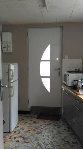 une cuisine avec une porte blanche et une fenêtre dans l'établissement Maison Jacquard chambre, à Rouen