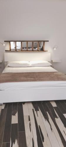 a bedroom with a large bed with a wooden floor at Do Mar in Bisceglie