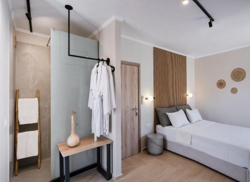 a white bedroom with a bed and a table at Baron Suites in Vasiliki