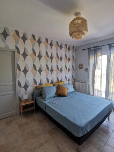 une chambre avec un lit avec une couette bleue dans l'établissement Le Loriot, à Auriol