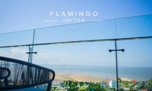 a glass window with a view of a beach at Flamingos Hải Tiến in Nam Khê