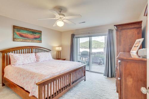 a bedroom with a bed with a ceiling fan and a window at Lake of The Ozarks Condo with Pool in Camdenton in Camdenton